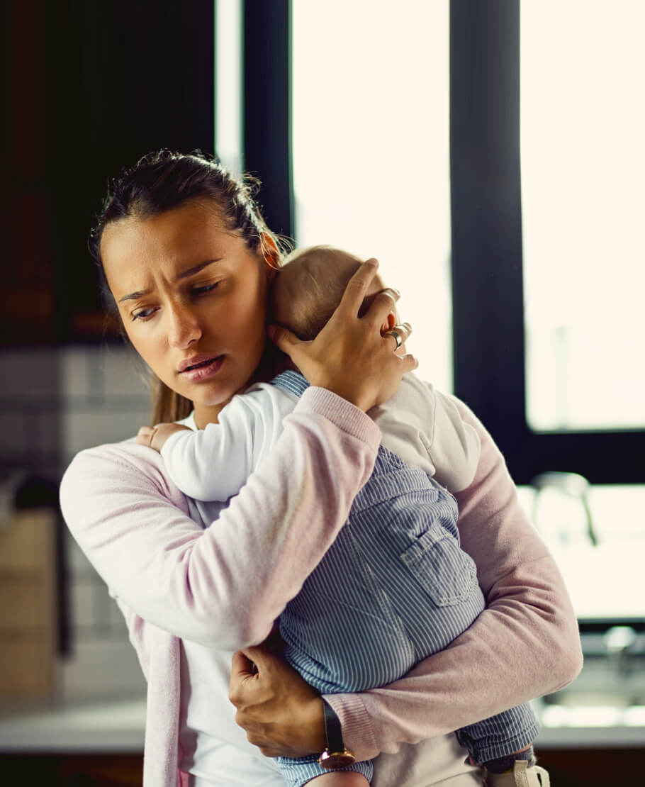 A mum holding a baby against her chest.